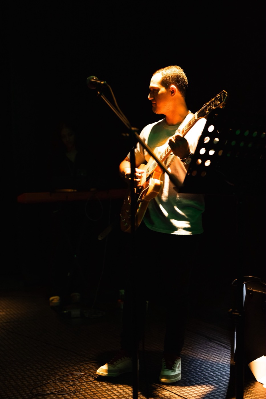 Daniel Puccini tocando guitarra en vivo bajo luz cálida